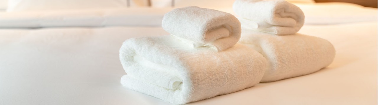 1440乘400像素的洗衣横幅，折叠毛巾放在酒店床上，商业网站