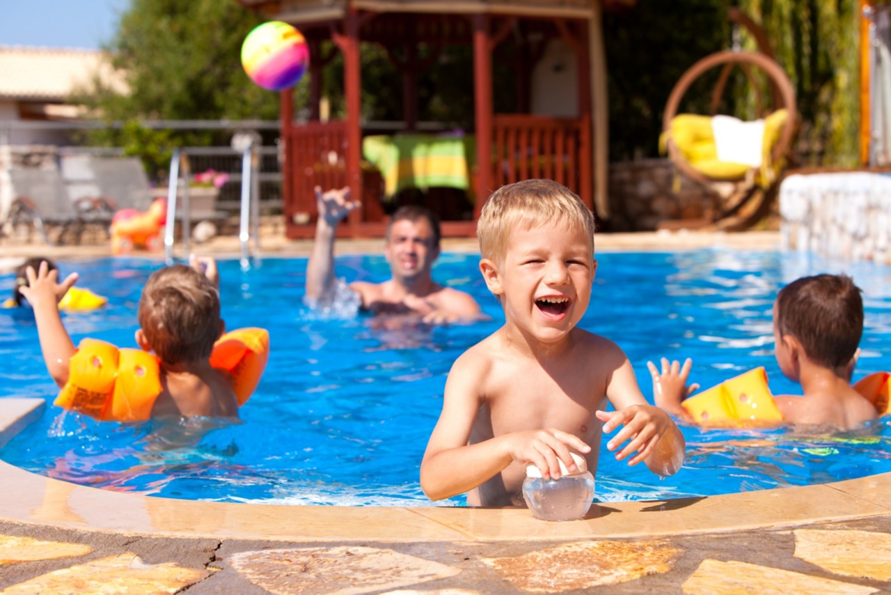 暑假，一群人在游泳池里玩得很开心。