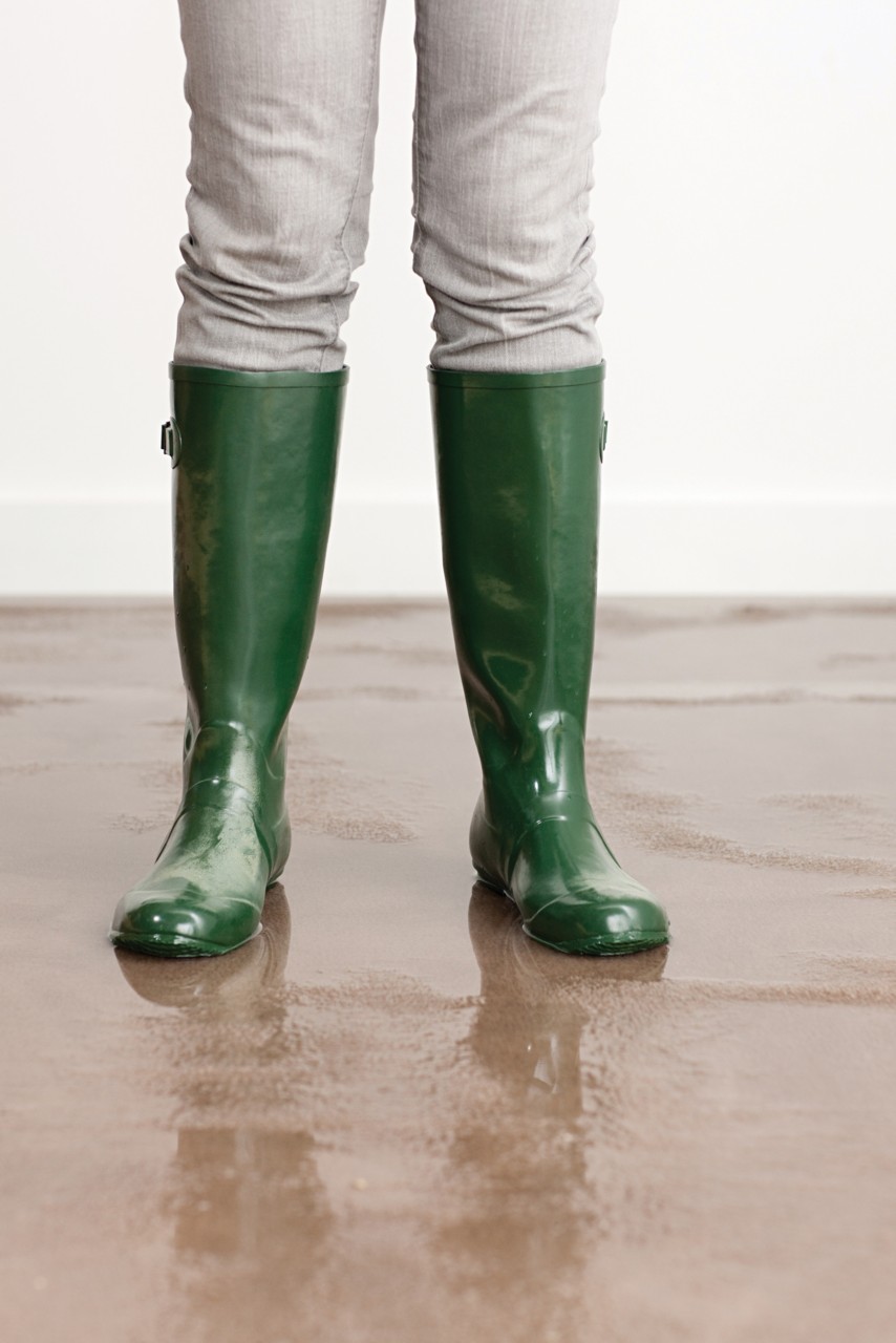 绿色雨靴踩在淹满水的棕色地毯上;一些:107908200”class=